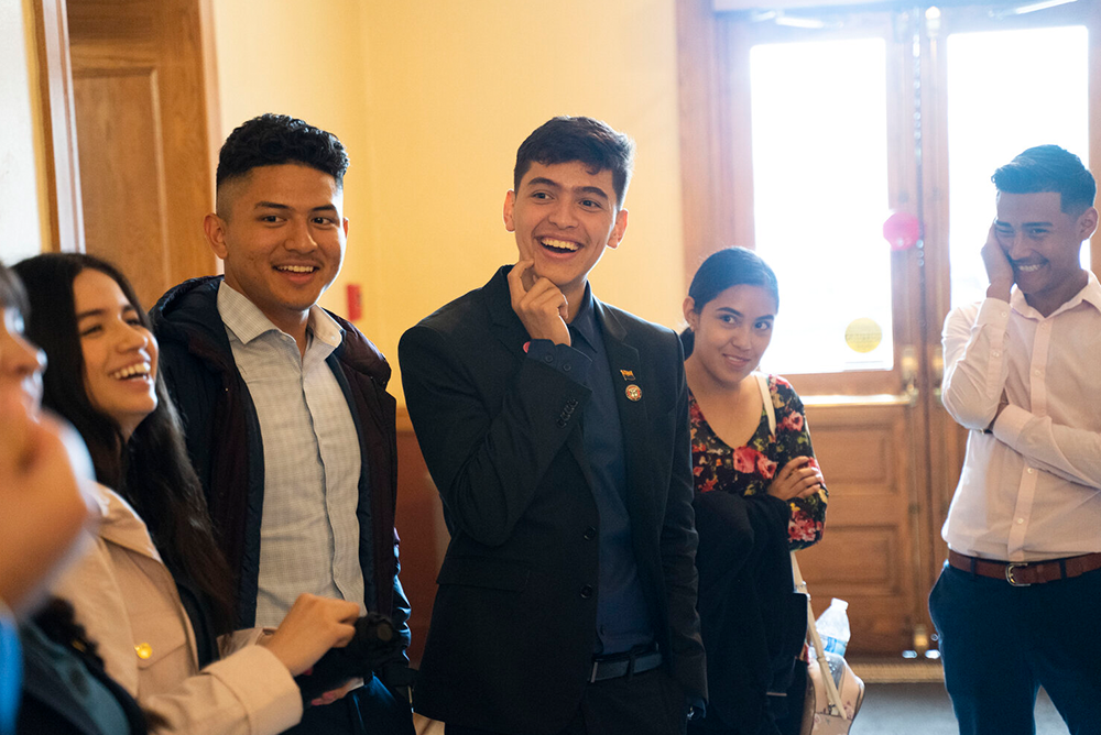 Angel Palazuelos smiling in conversation surrounded by five peers